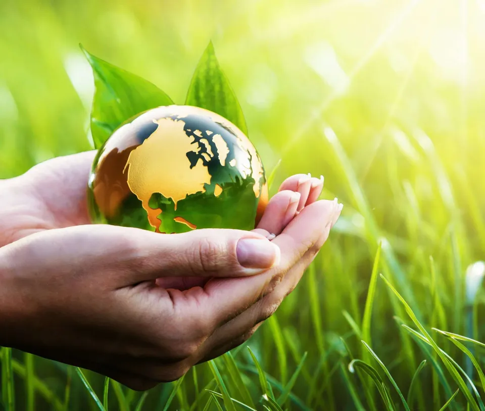 Sustainable visual merchandising point of sale, being represented by woman holding a greener earth in her hands.