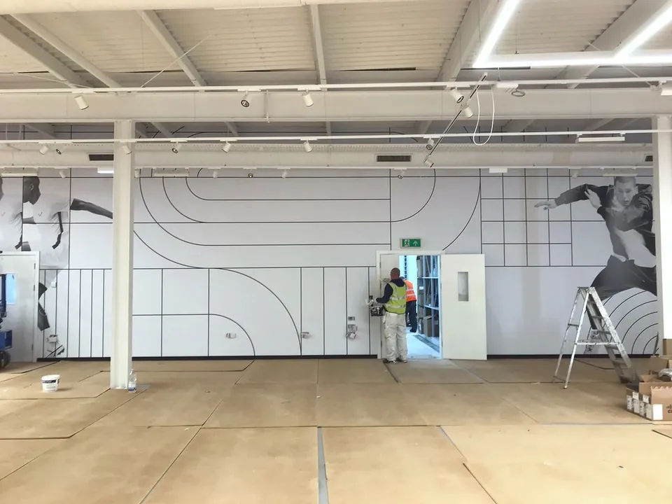 Nike retail interior with campaign imagery across the wall