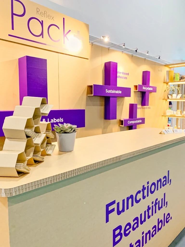 Reflex exhibition counter and purple material-message shelves with exposed board construction